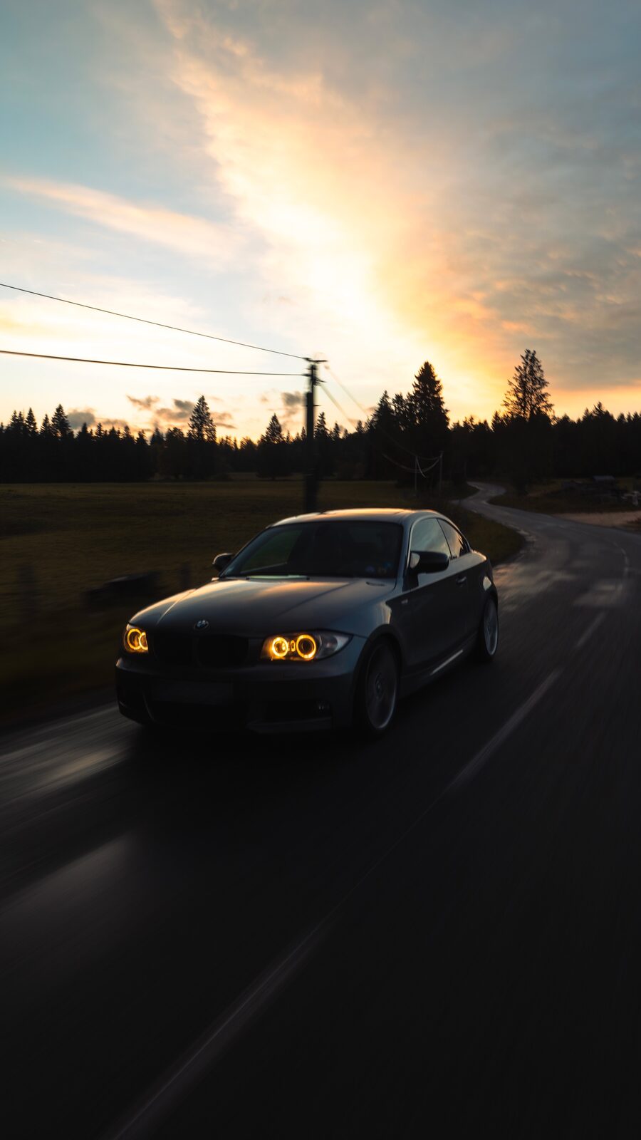 BMW Série 1 coupé dans une route en forêt